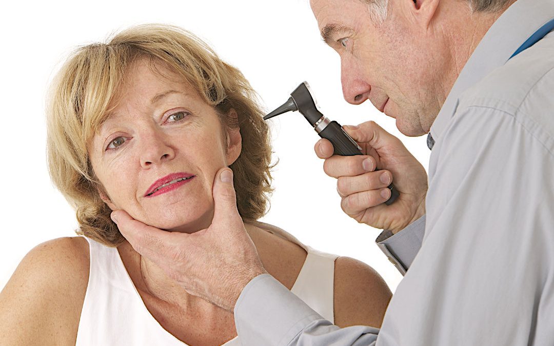 Doctor checking woman's ear